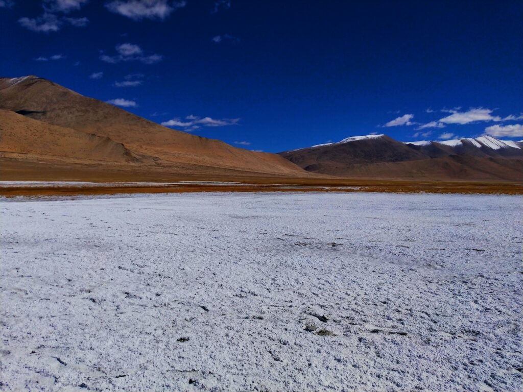 a man riding a snowboard across a snow covered field
